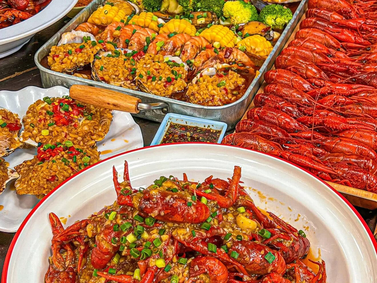 A Chongqing table of jianghu dishes: a platter of crayfish with several chilli-heavy plates, set up for sharing
