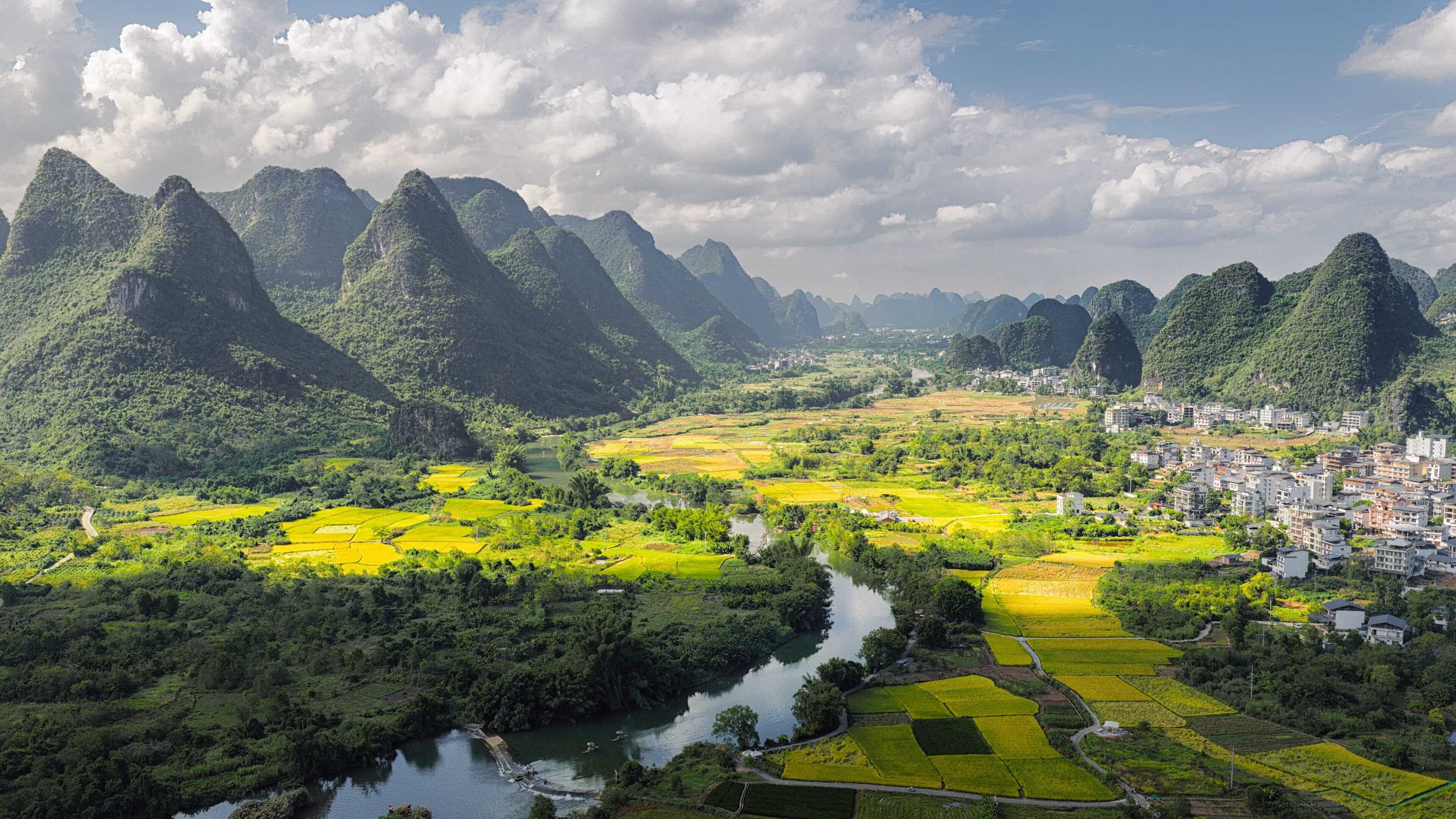 A karst valley with yellow fields and a white-walled settlement