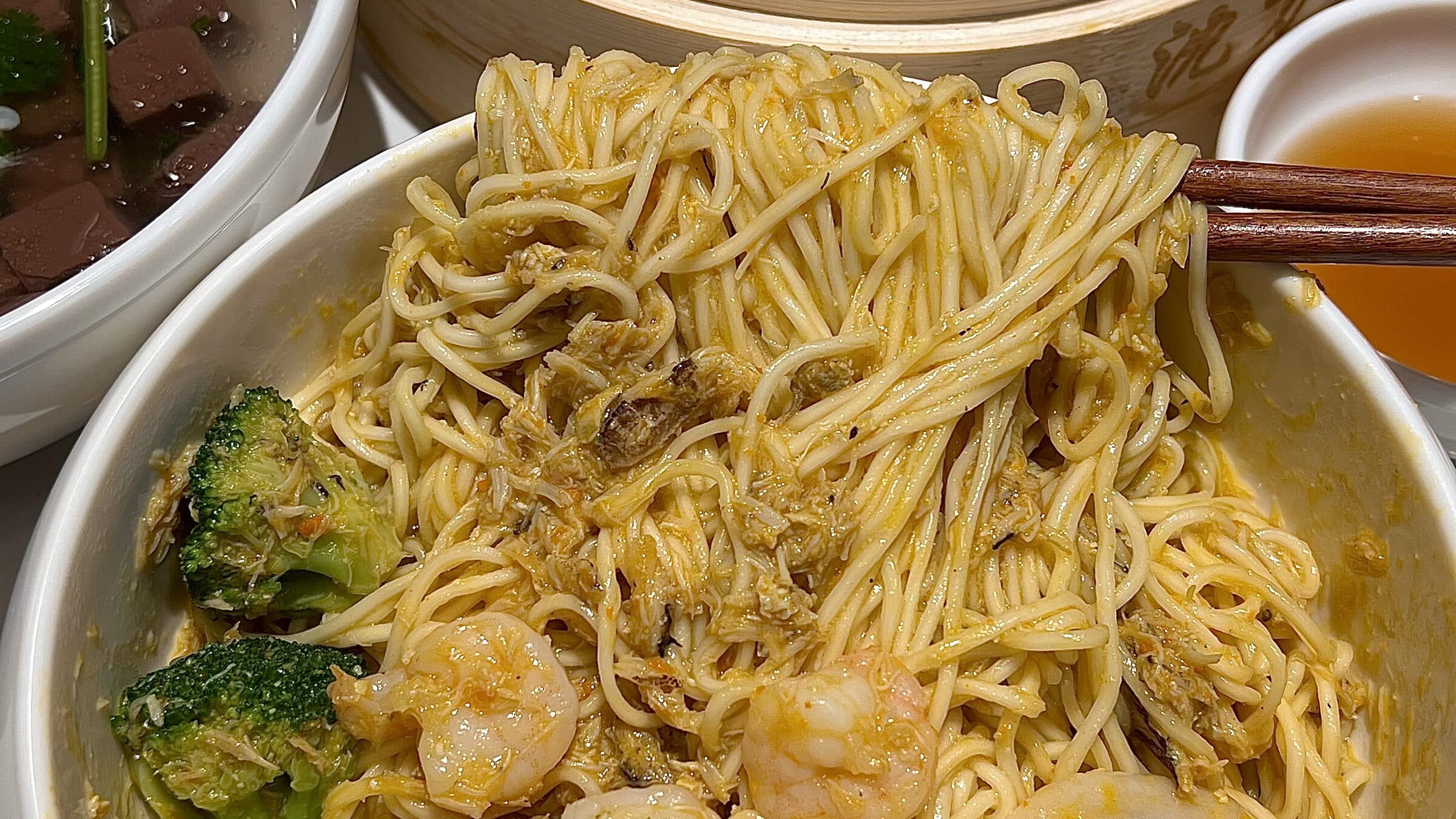 A Hangzhou table of noodles with shrimp, side dishes and bowls of soup