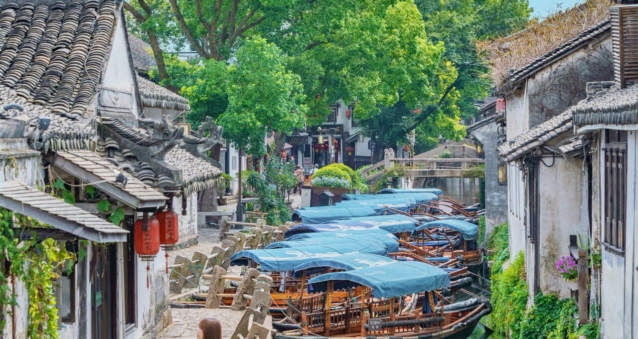 White-walled, dark-tiled houses and landing steps lining a water-town canal