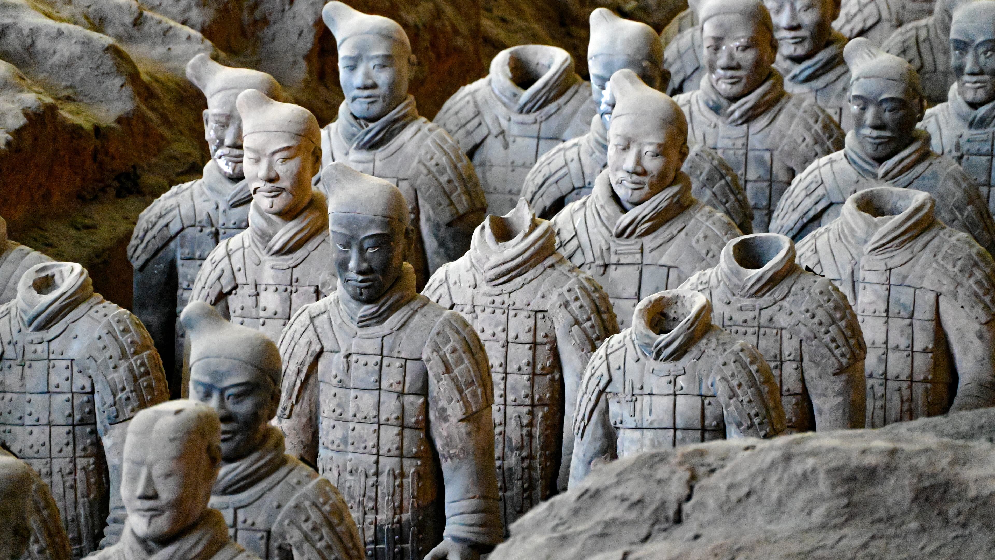 Rows of terracotta warriors from the waist up, with armour and topknots in detail