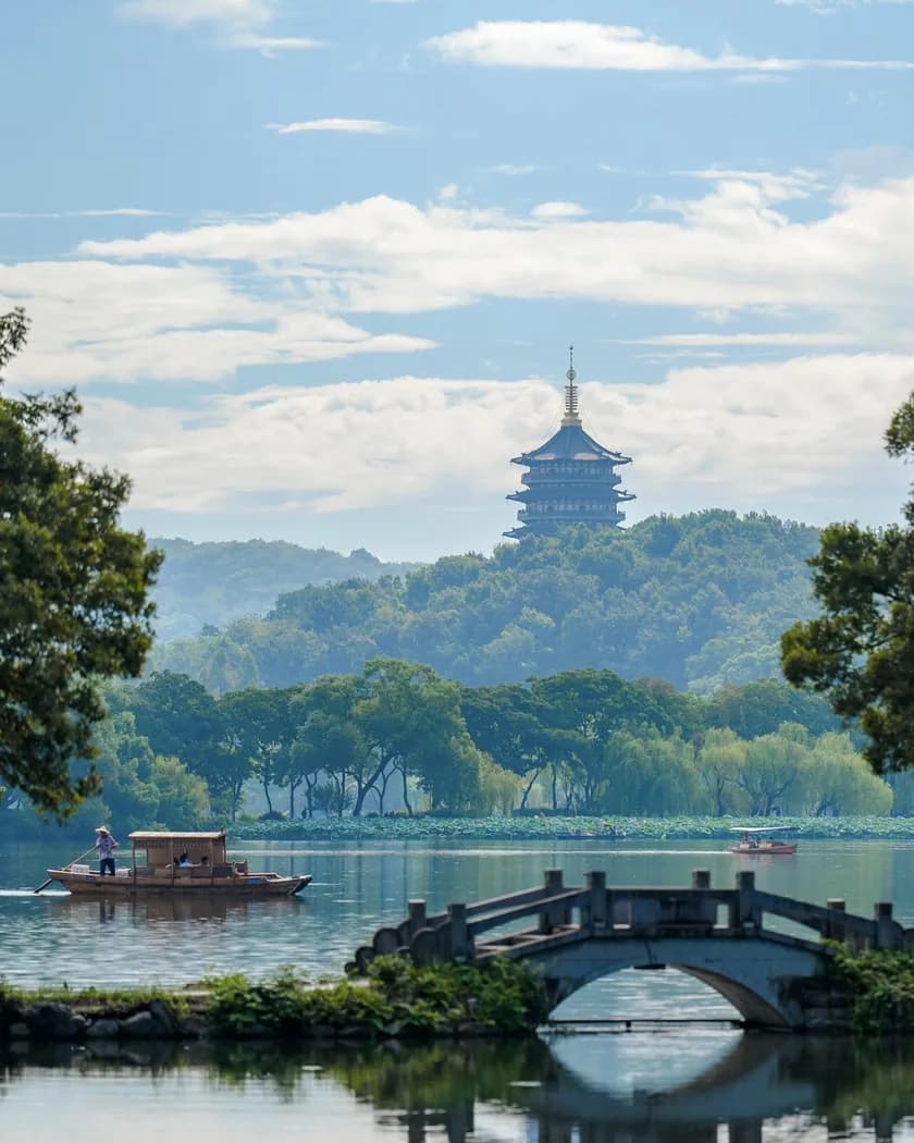 A pagoda on a wooded hill above West Lake in Hangzhou