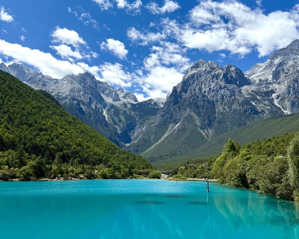 Snow-capped peaks above a forested valley in Yunnan