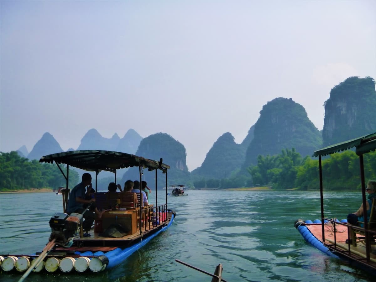 Bamboo raft drifting through karst peaks on the Li River at dawn
