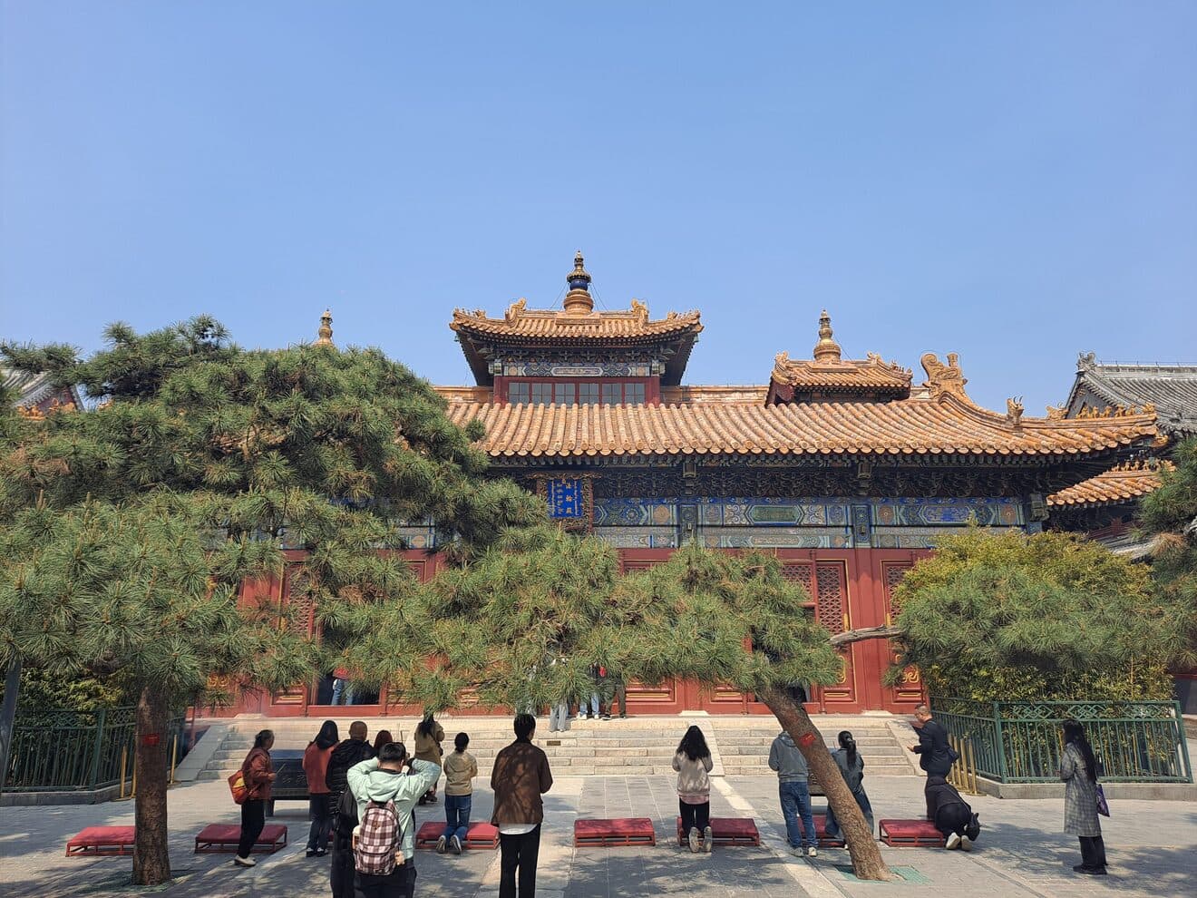 The Falun Hall at Yonghe Temple: a double-eaved hall with golden glazed tiles and vermilion columns above a stone courtyard