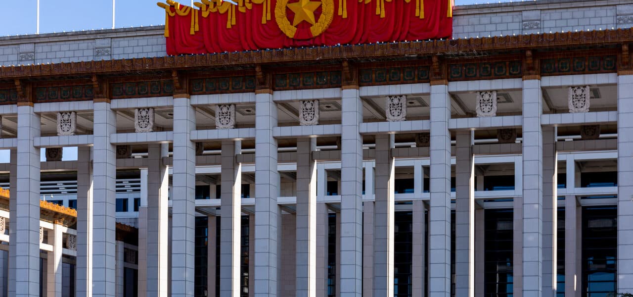The facade of the National Museum of China: colonnade, red star and banner under a grey sky