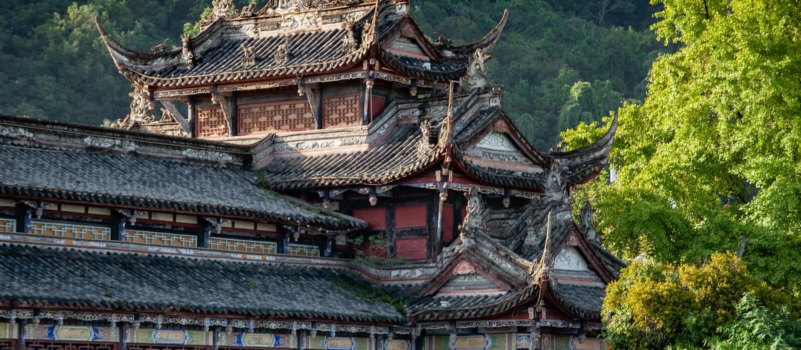 Riverside halls near Dujiangyan: tiered roofs with a pagoda on the hill above