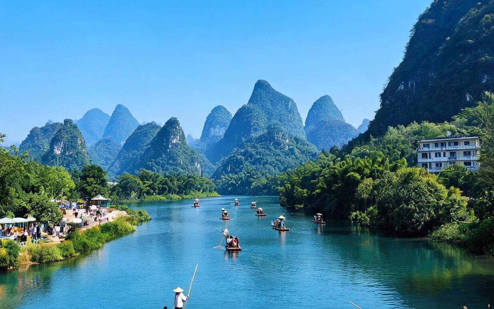 A line of bamboo rafts with their boatmen on the Li River below karst peaks
