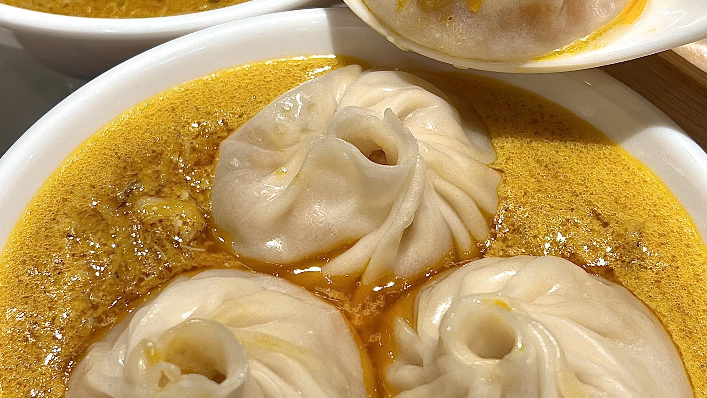 Three crab-and-pork soup dumplings in golden broth