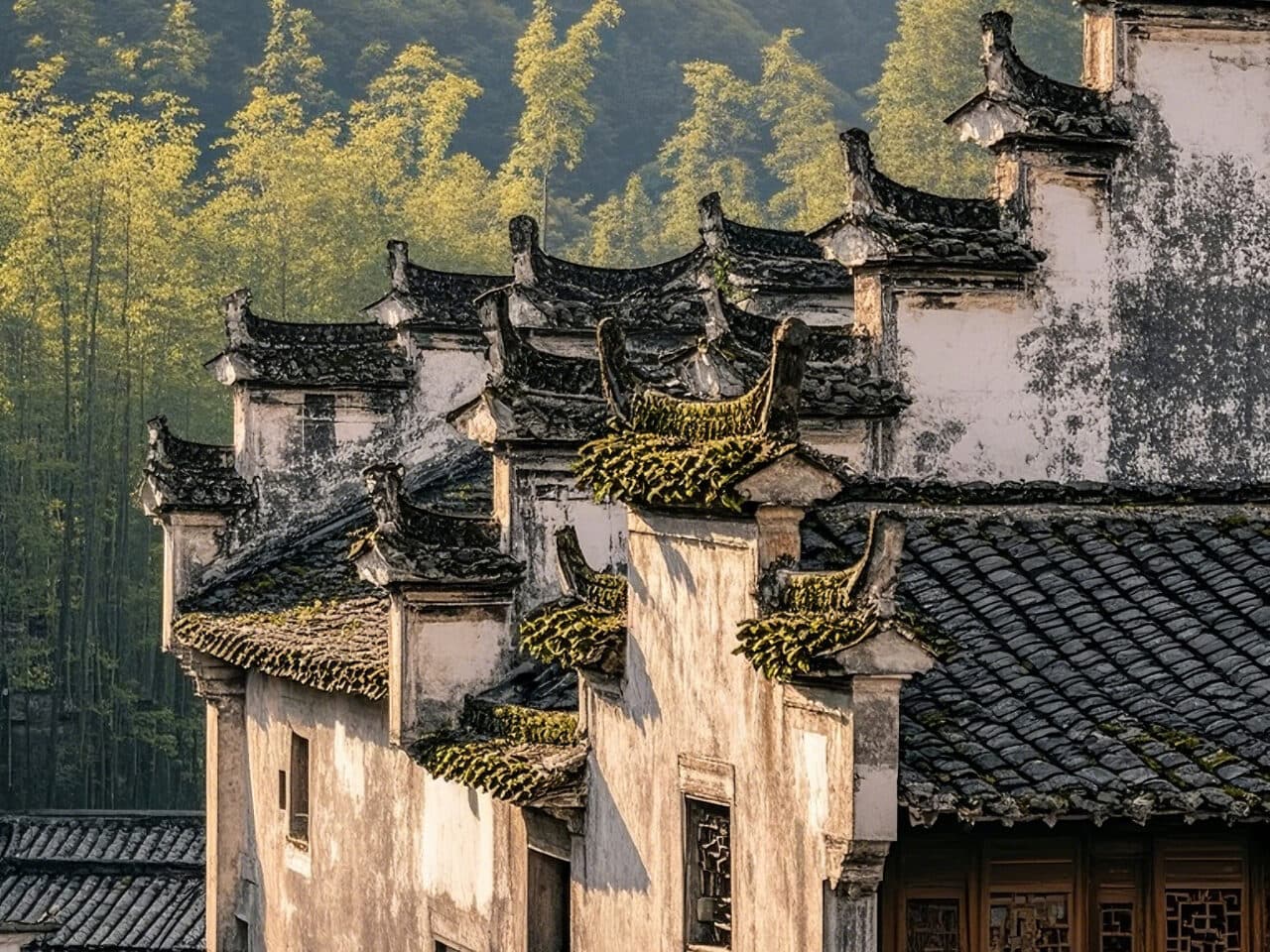 Stepped horse-head gables and small grey roof tiles of a Hui-style house, with bamboo behind