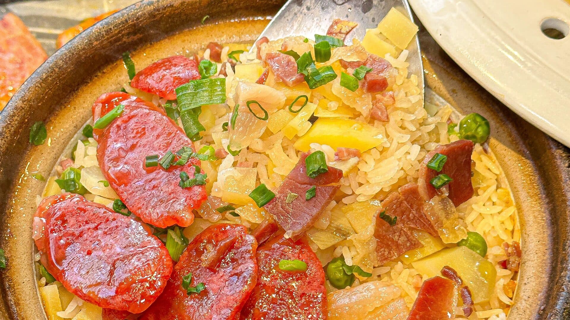 A Yunnan home-style stir-fry of cured meat with tomato and green pepper served on a shallow plate