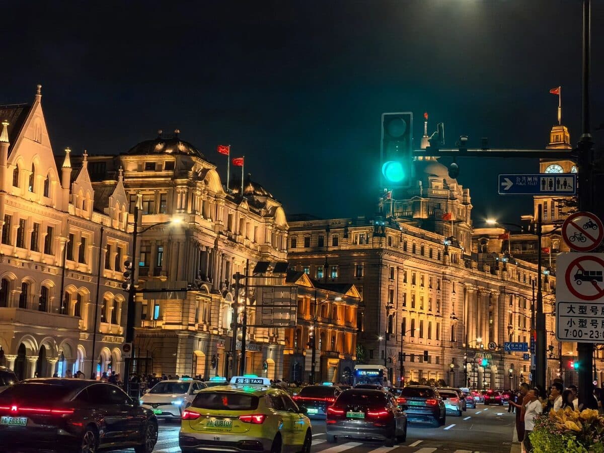 The Bund in Shanghai at night, the historic waterfront buildings lit in warm light along the street