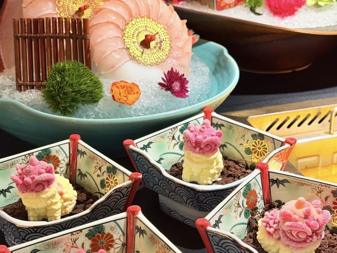 Flower-shaped milk-pudding desserts in wooden boxes with small pastries beside them