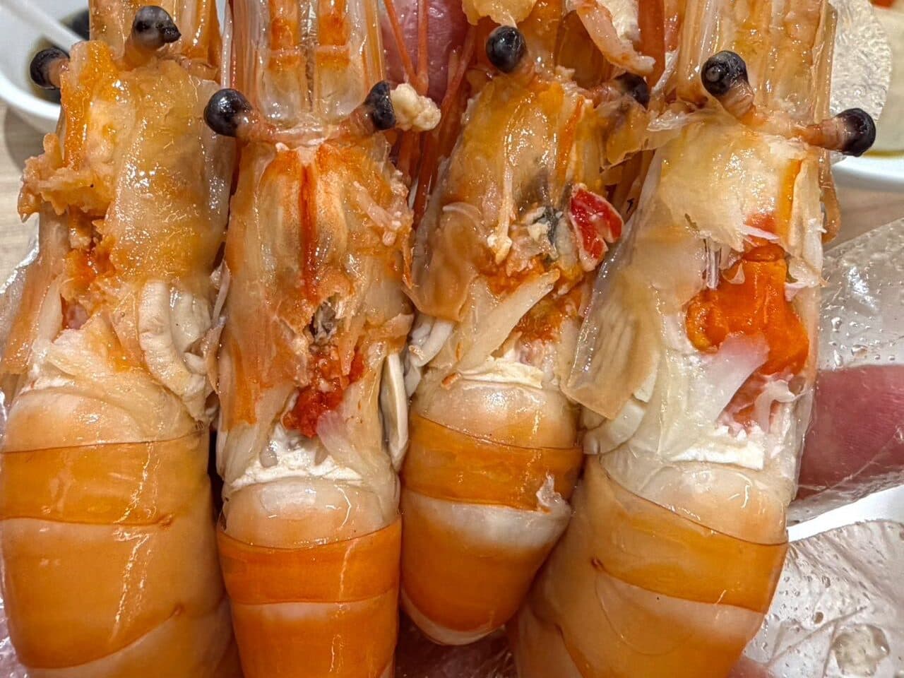 A plate of steamed prawns with roe, plated for sharing