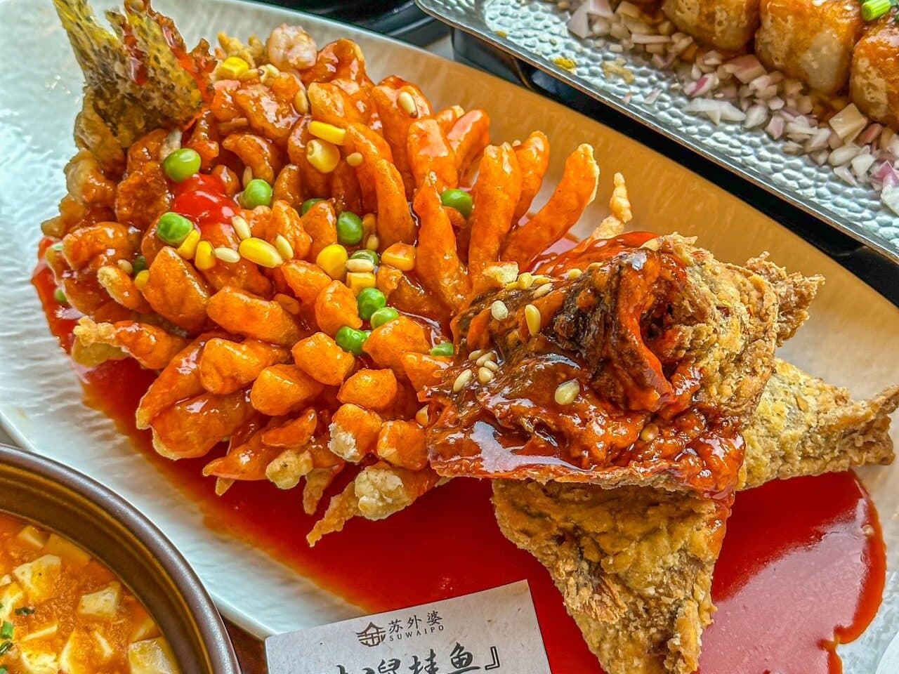 Squirrel-shaped mandarin fish plated beside another dish, set up for sharing