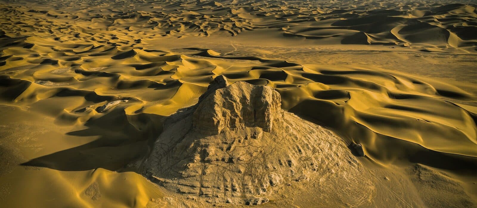 Dunes and rock formations in the Kumtag Desert, seen from above