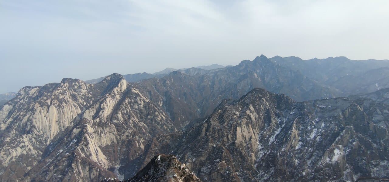 The Huashan peaks: grey-blue rock faces and layered ridges stretching under cloud