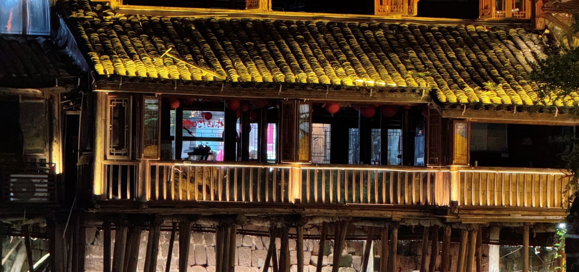 Lit stilt houses over the water at night