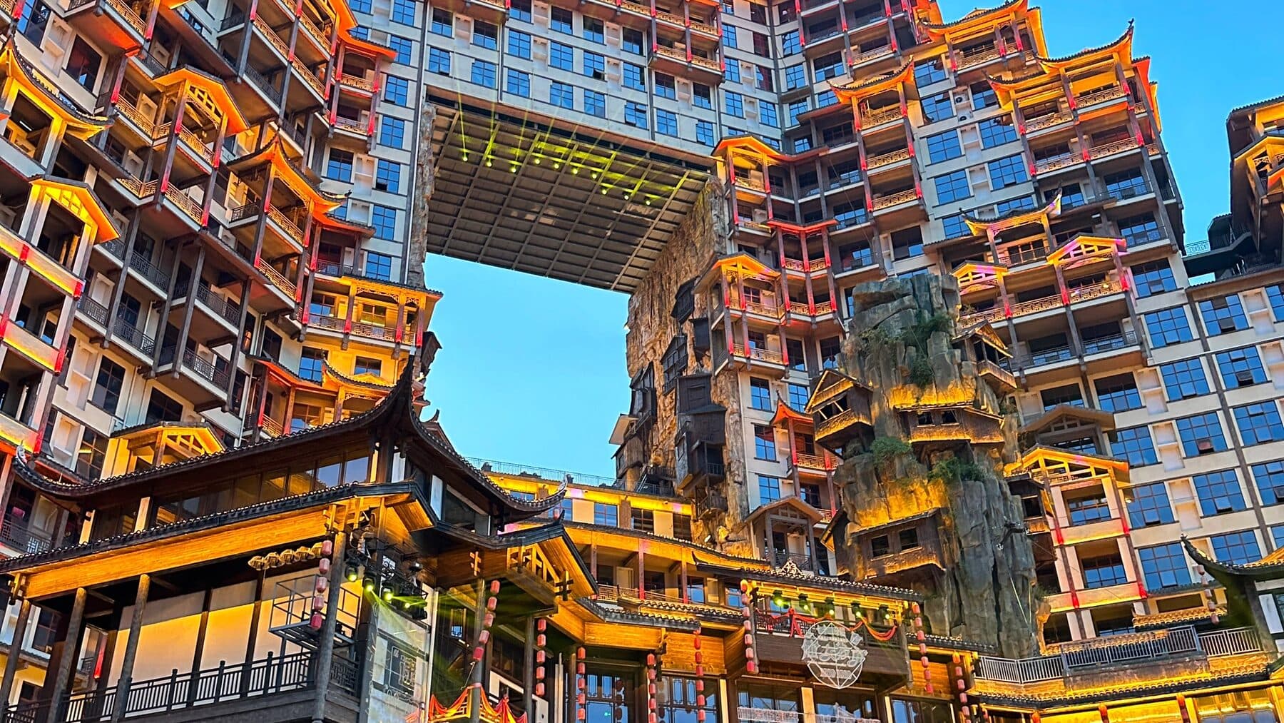 Tiered Chinese-roofed building complex lit at dusk in Zhangjiajie city