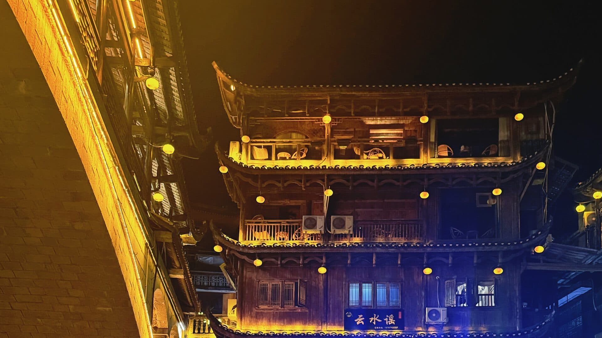 Multi-storey timber building with lit lanterns at night