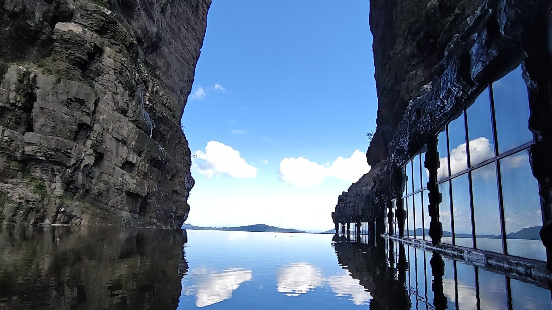 Glass-panelled cliff walkway on the rock face above the water