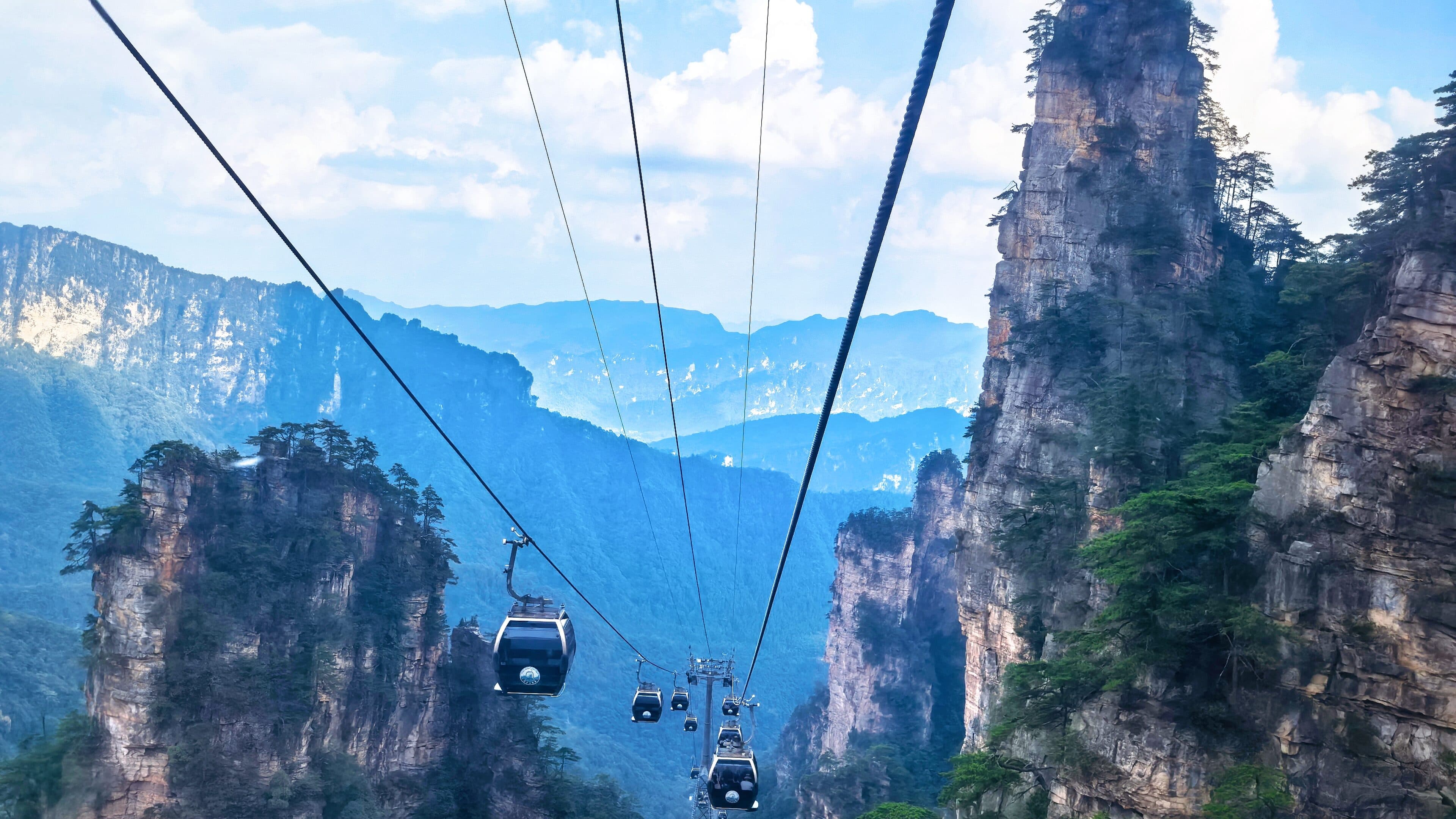 Cable cars above forested sandstone pillars near Zhangjiajie