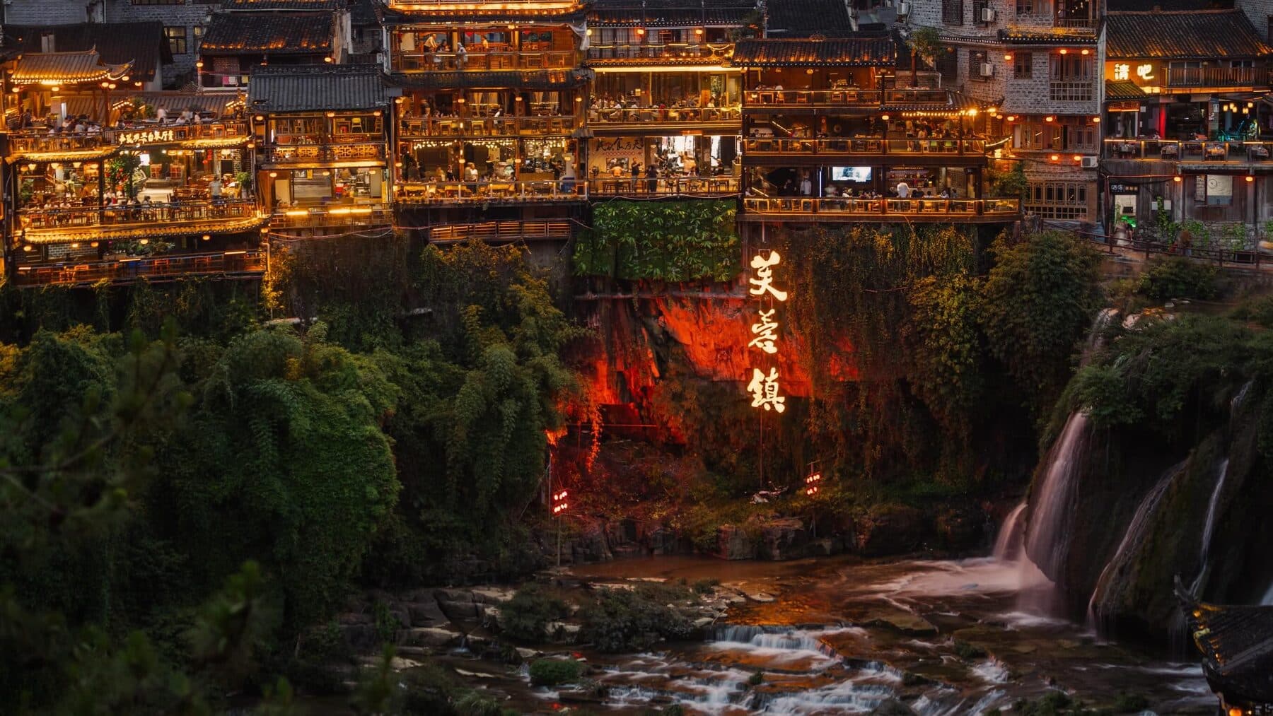 Furong Town waterfall and old houses lit up at night