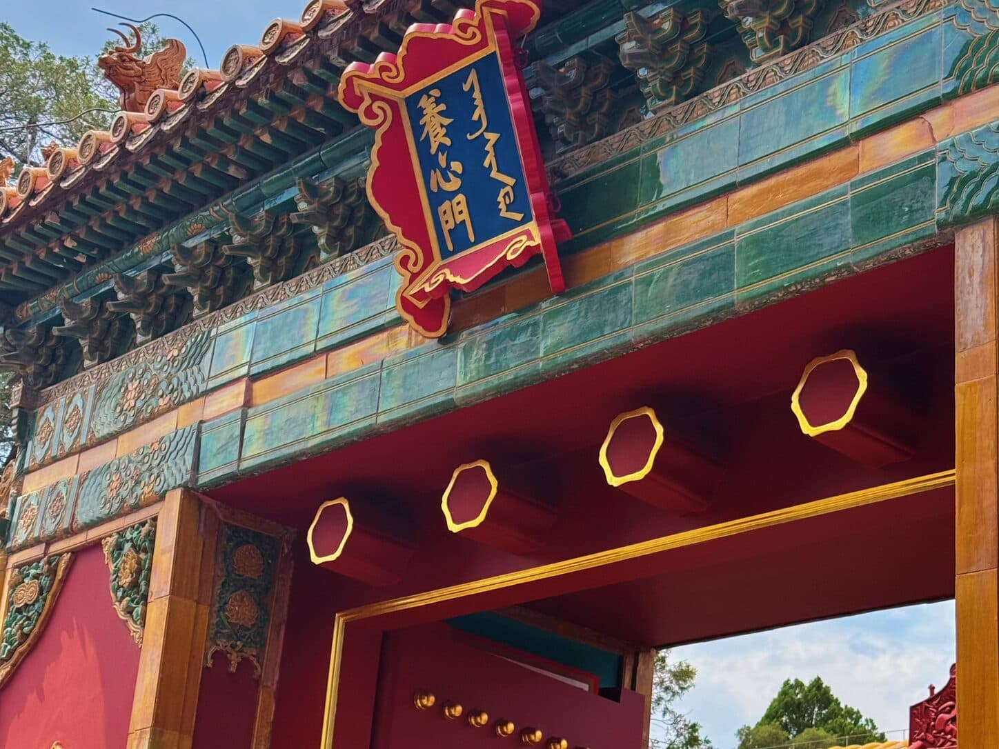 A painted palace gate with gold-studded doors in Beijing