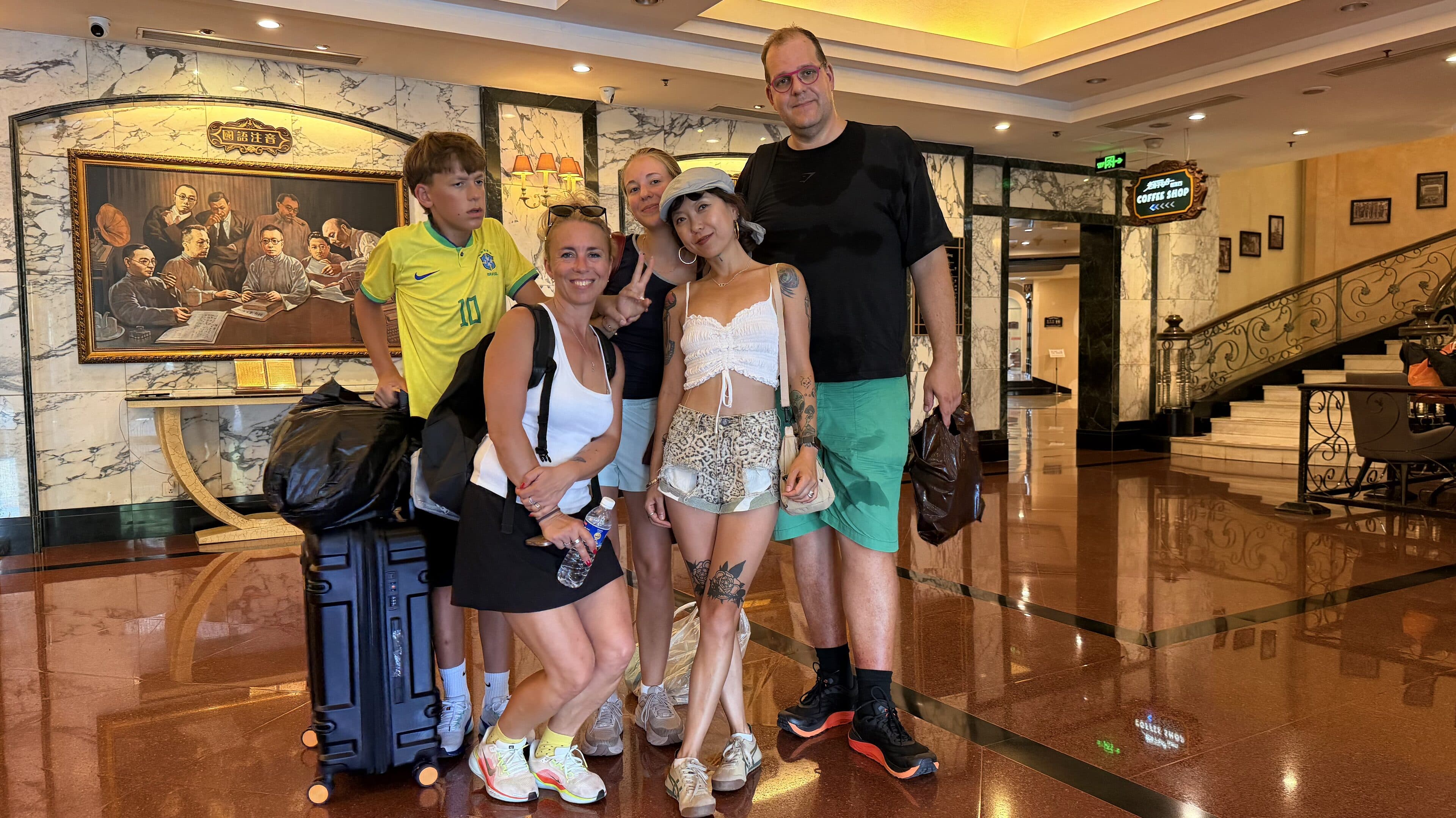 A group of travellers with suitcases standing in a hotel lobby